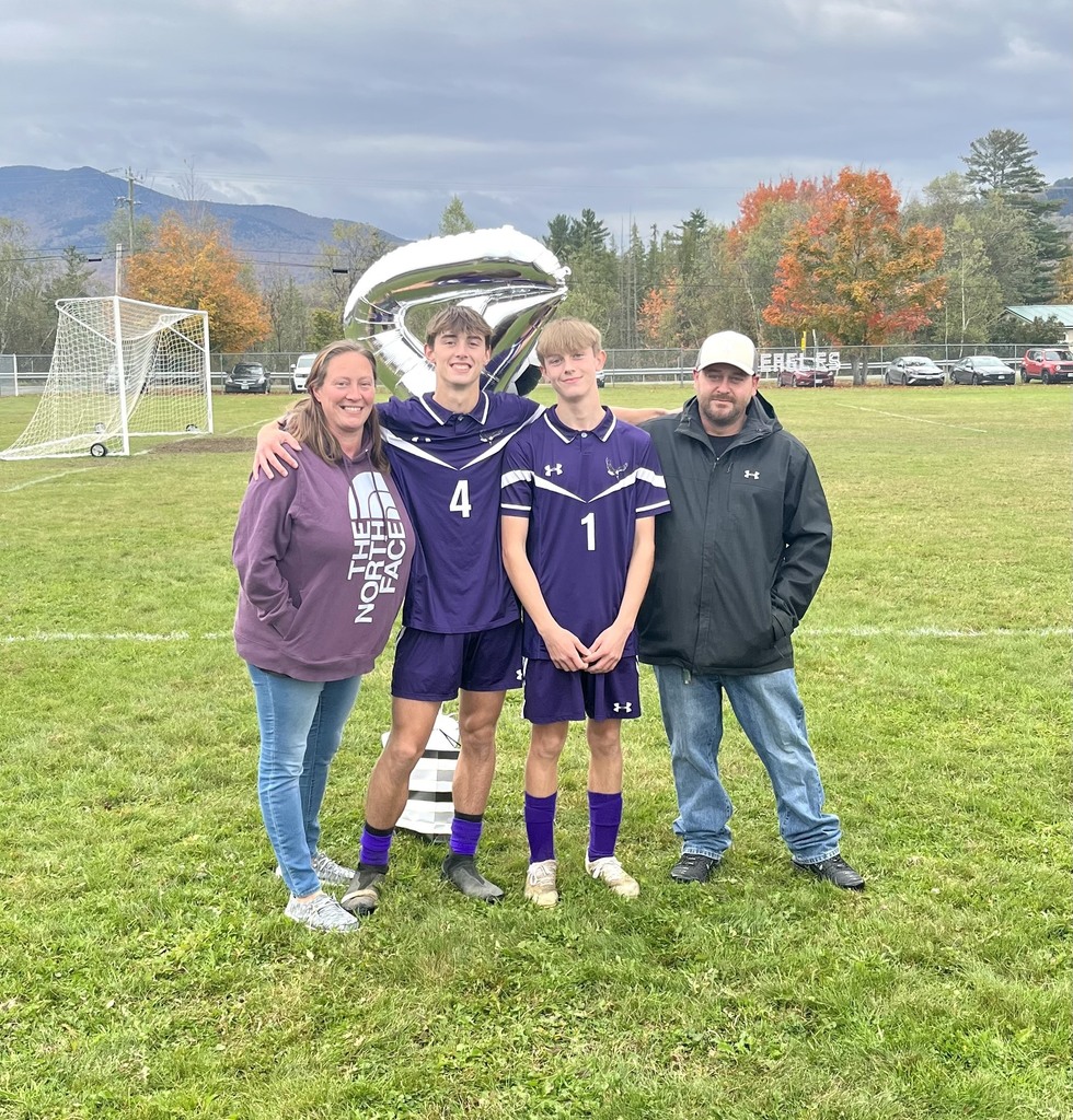 Family of 4 standing for a picture with the two boy soccer players