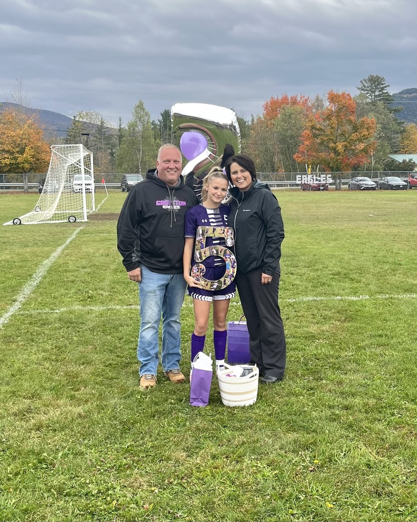 A Family of three standing with their senior soccer player